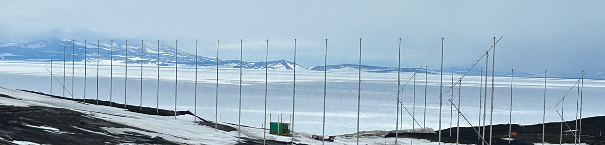 A row of HF antennas against an Antarctic landscape.